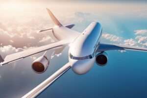Commercial airplane flying above clouds during daytime.